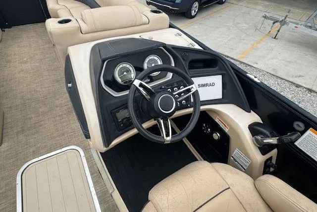 Slide: The Image of 2020 Barletta Lusso 25QCSS boat dashboard with steering wheel and Simrad display. - 16