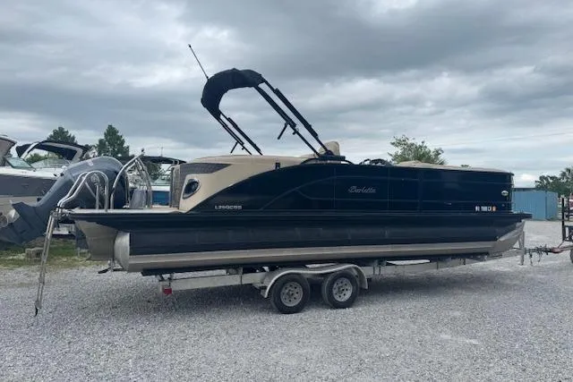 Slide: The Image of 2020 Barletta Lusso 25QCSS pontoon boat on a trailer under cloudy skies. - 4