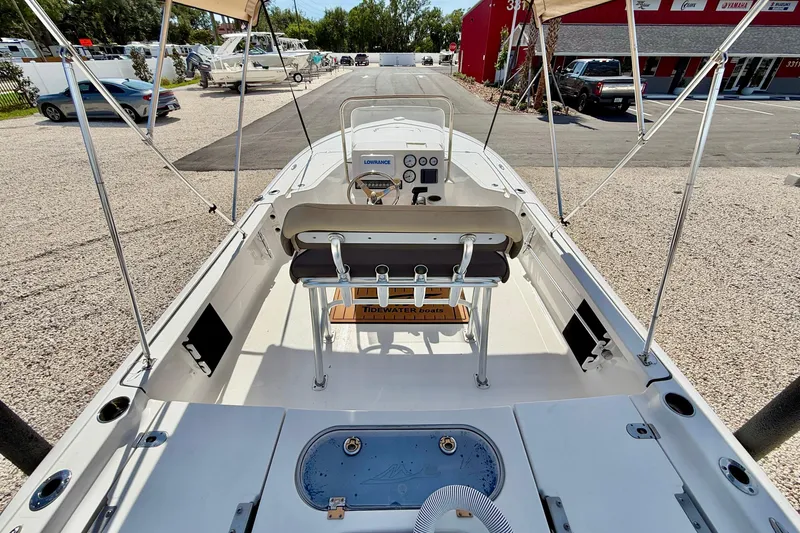 Slide: The Image of 2021 Tidewater 1910 Bay Max boat interior with console and seating, parked outdoors. - 17