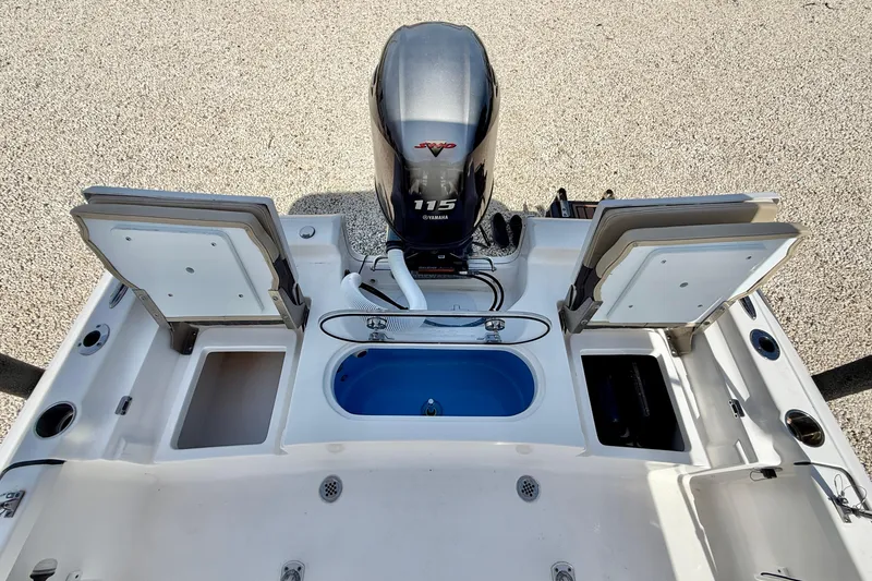 Slide: The Image of 2021 Tidewater 1910 Bay Max boat with Yamaha 115 engine and open storage compartments. - 24