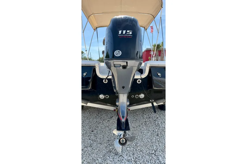 Slide: The Image of 2021 Tidewater 1910 Bay Max boat with 115 horsepower outboard motor, parked on gravel. - 27