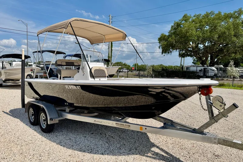 Slide: The Image of 2021 Tidewater 1910 Bay Max boat on trailer, featuring a sleek black hull and canopy. - 3