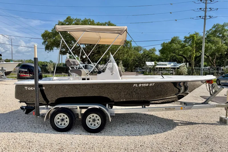 Slide: The Image of 2021 Tidewater 1910 Bay Max boat on trailer, featuring a Yamaha engine and canopy. - 7