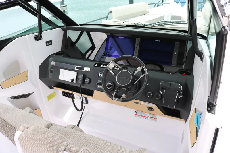 Slide: The Image of 2026 Axopar 29 Sun-Top boat cockpit with modern steering and navigation displays. - 13