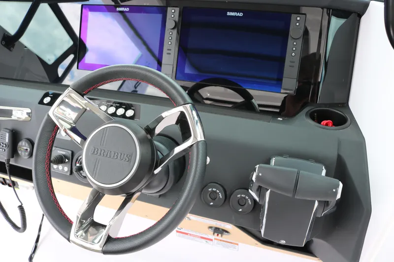 Slide: The Image of Steering wheel and dashboard of 2026 Axopar 29 Sun-Top boat with Simrad displays. - 14