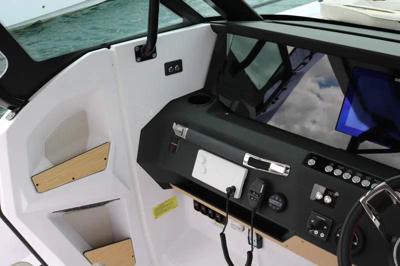Slide: The Image of Interior dashboard of 2026 Axopar 29 Sun-Top boat with modern controls and steering. - 15