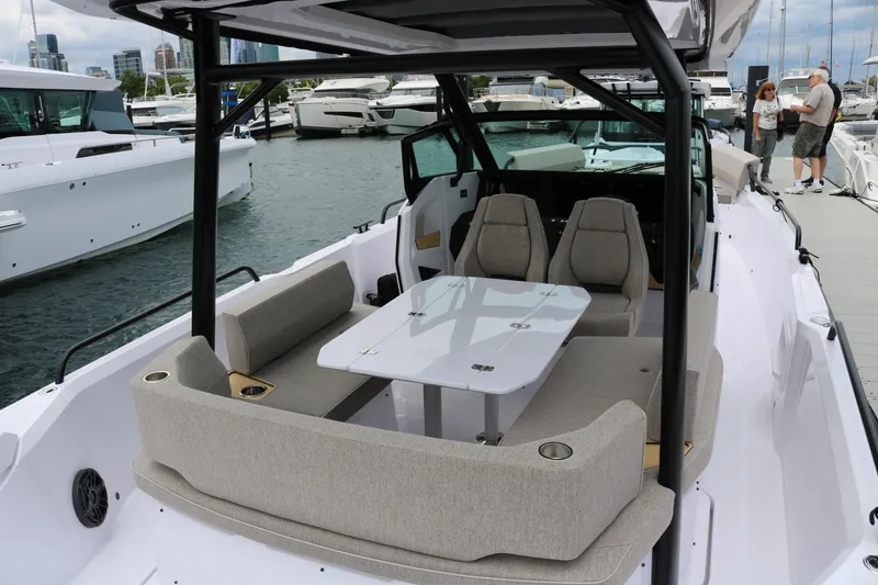 Slide: The Image of 2026 Axopar 29 Sun-Top boat interior with seating and table, docked at marina. - 22