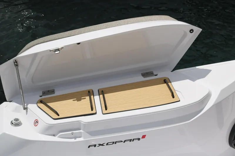 Slide: The Image of 2026 Axopar 29 Sun-Top boat storage compartment open, showcasing interior design. - 23