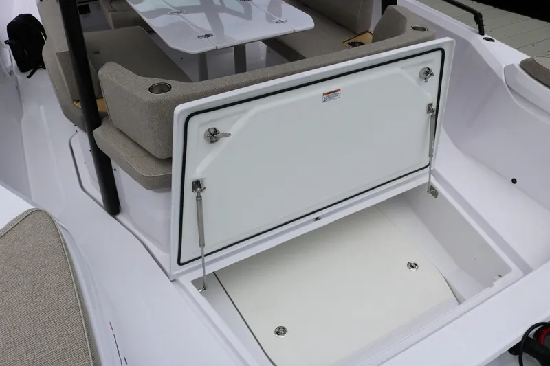 Slide: The Image of 2026 Axopar 29 Sun-Top boat interior with open storage compartment and seating area. - 26