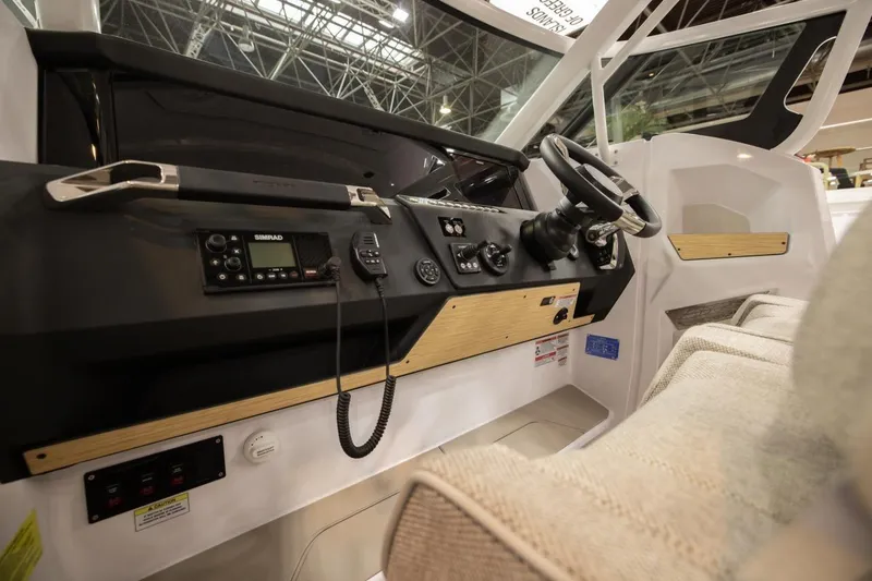 Slide: The Image of Interior view of 2026 Axopar 29 Sun-Top boat cockpit with steering wheel and controls. - 4