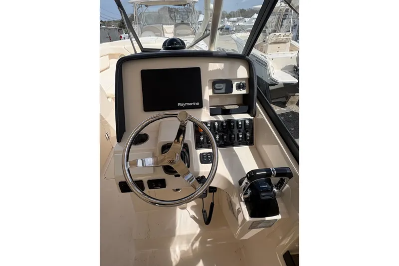 Slide: The Image of 2016 Grady-White Freedom 275 boat helm with Raymarine display and controls. - 6