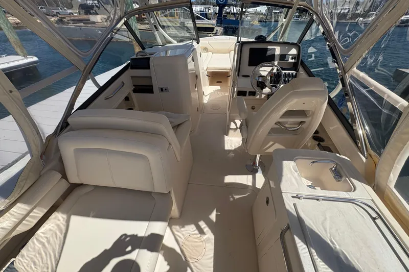 Slide: The Image of 2016 Grady-White Freedom 275 boat interior with helm, seating, and sink. - 8