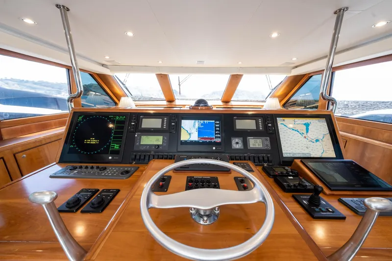 Slide: The Image of 2001 Donzi yacht helm with advanced navigation systems and wooden dashboard. - 16