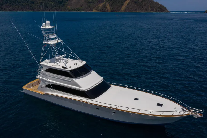 Slide: The Image of Luxury 2001 Donzi yacht cruising on open sea with scenic island backdrop. - 2