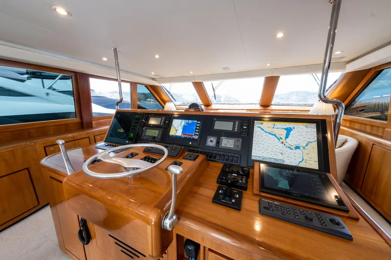 Slide: The Image of 2001 Donzi yacht helm with advanced navigation systems and wooden interior design. - 32