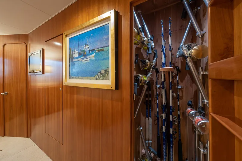 Slide: The Image of Wood-paneled hallway on a 2001 Donzi boat with fishing rods and nautical artwork. - 44