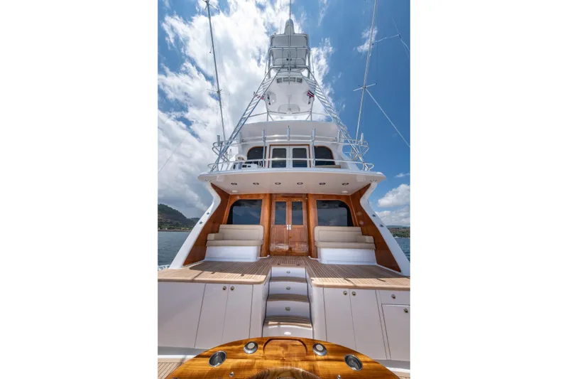 Slide: The Image of 2001 Donzi yacht with sleek design, wooden accents, and spacious deck under a clear blue sky. - 57