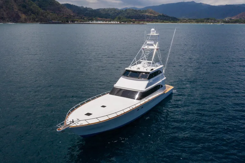 Slide: The Image of 2001 Donzi yacht cruising on serene waters with mountainous backdrop. - 6