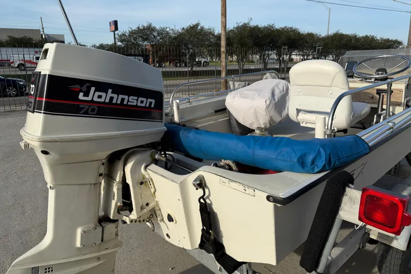Slide: The Image of 1983 Boston Whaler Sport 15 boat with Johnson 70 outboard motor, parked outdoors. - 5