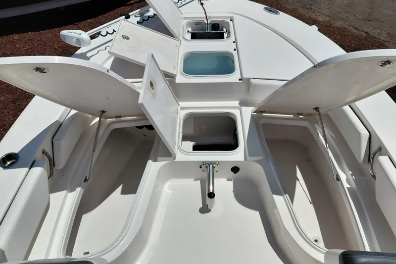 Slide: The Image of 2023 Robalo 246 Cayman boat with open storage compartments and seating area. - 17