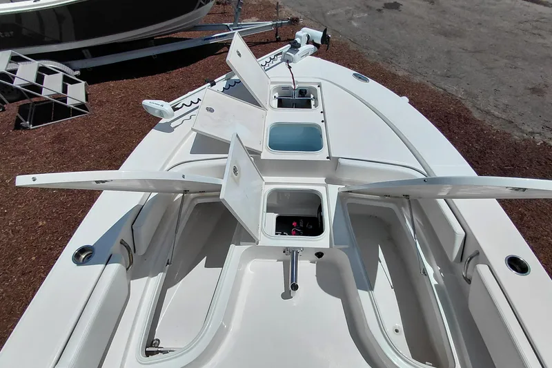 Slide: The Image of 2023 Robalo 246 Cayman boat deck with open storage compartments and fishing gear. - 18