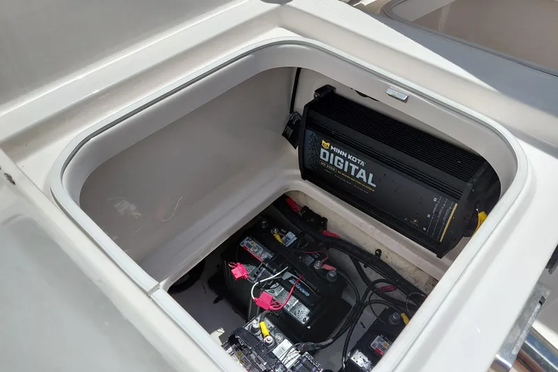 Slide: The Image of 2023 Robalo 246 Cayman boat battery compartment with Minn Kota digital charger. - 19