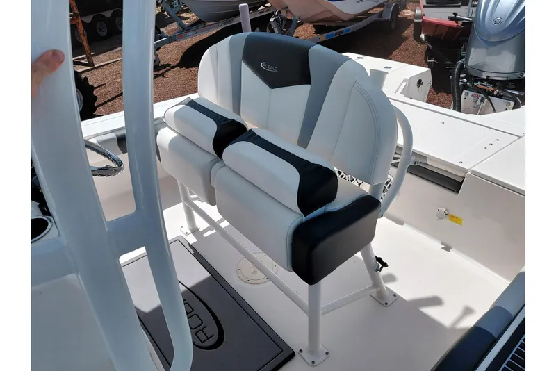 Slide: The Image of 2023 Robalo 246 Cayman boat interior with cushioned seating and steering wheel. - 32