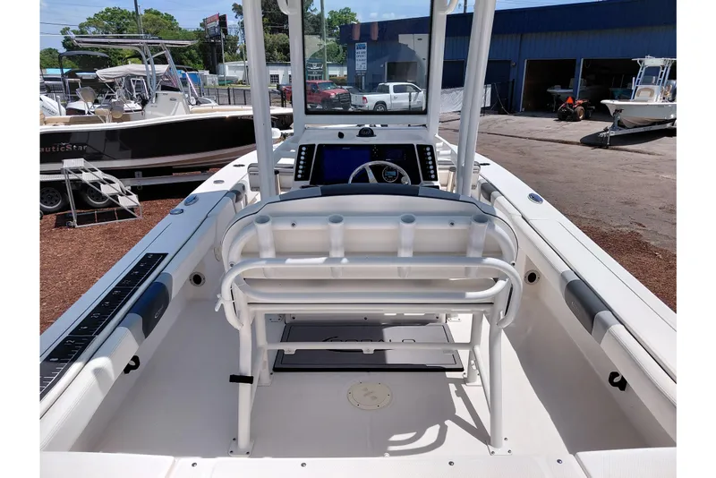 Slide: The Image of 2023 Robalo 246 Cayman boat interior with helm and seating, displayed outdoors. - 35