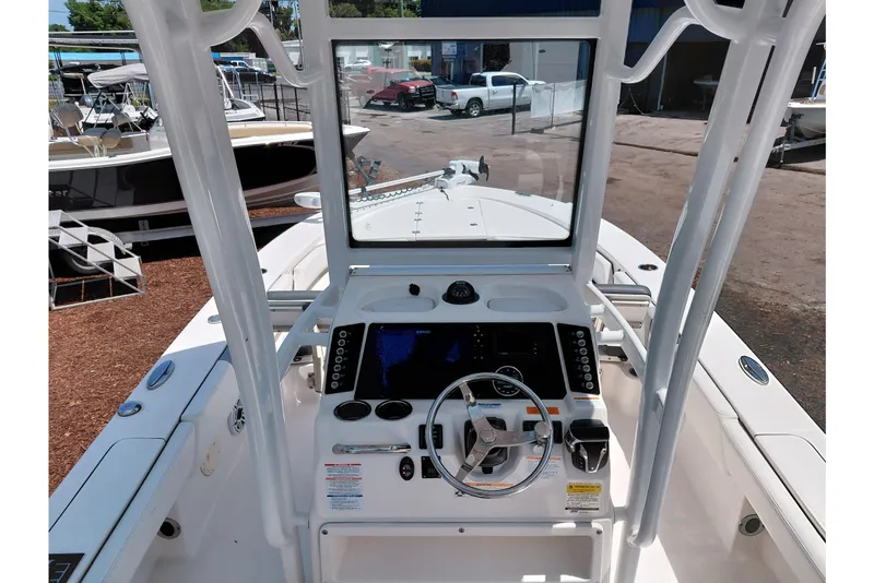 Slide: The Image of 2023 Robalo 246 Cayman boat dashboard with steering wheel and navigation controls. - 38