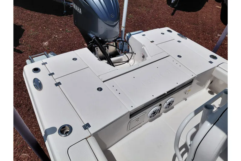 Slide: The Image of 2023 Robalo 246 Cayman boat deck with Yamaha engine, featuring storage and speakers. - 45