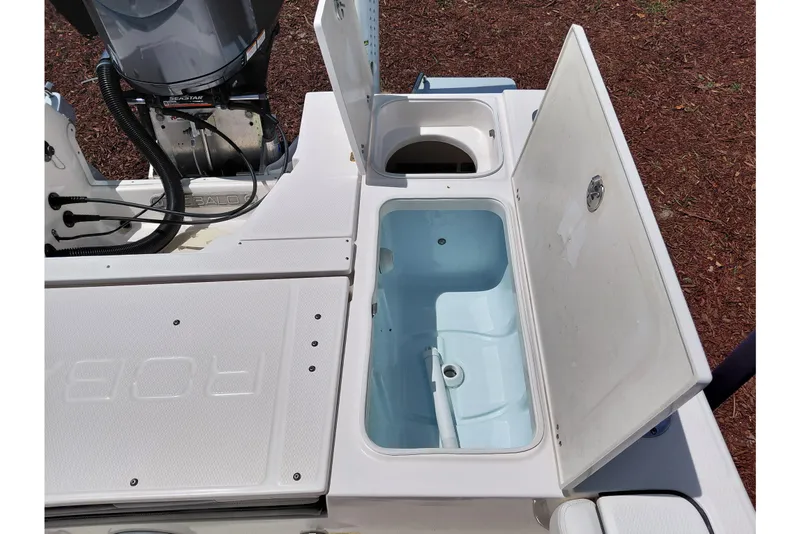 Slide: The Image of 2023 Robalo 246 Cayman boat storage compartments and engine detail. - 47