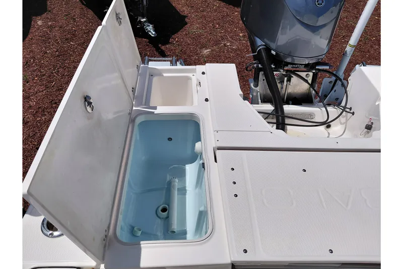 Slide: The Image of 2023 Robalo 246 Cayman boat's open storage compartments and engine detail. - 48