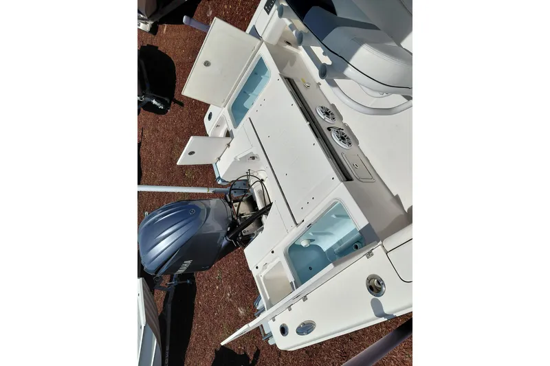 Slide: The Image of 2023 Robalo 246 Cayman boat with open storage compartments and Yamaha outboard motor. - 49