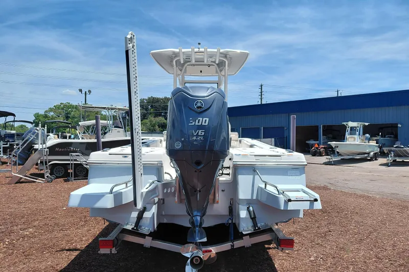 Slide: The Image of 2023 Robalo 246 Cayman boat with Yamaha V6 engine, displayed outdoors at a dealership. - 6