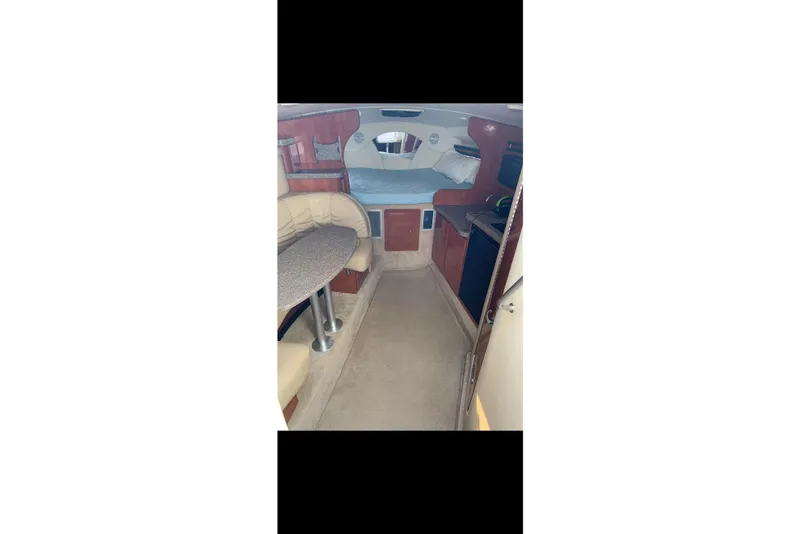 Slide: The Image of Interior of 2005 Rinker Fiesta Vee 320 boat, featuring seating and sleeping area. - 10