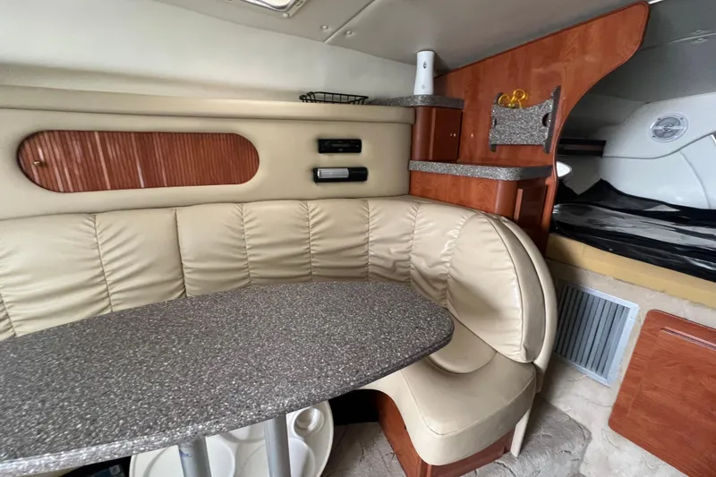 Slide: The Image of 2005 Rinker Fiesta Vee 320 cabin interior with beige seating and wooden accents. - 3