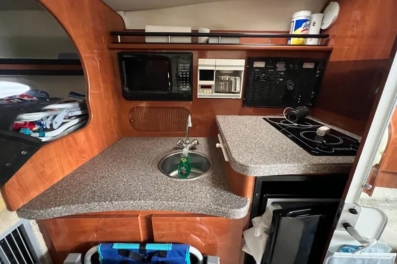 Slide: The Image of 2005 Rinker Fiesta Vee 320 boat kitchen with microwave, sink, and stove. - 5