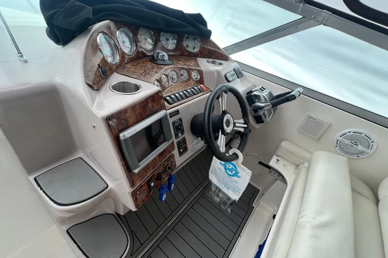 Slide: The Image of 2005 Rinker Fiesta Vee 320 boat cockpit with steering wheel, gauges, and navigation equipment. - 6
