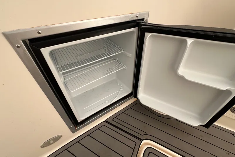 Slide: The Image of Open refrigerator on 2005 Rinker Fiesta Vee 320 boat, showing empty shelves. - 7
