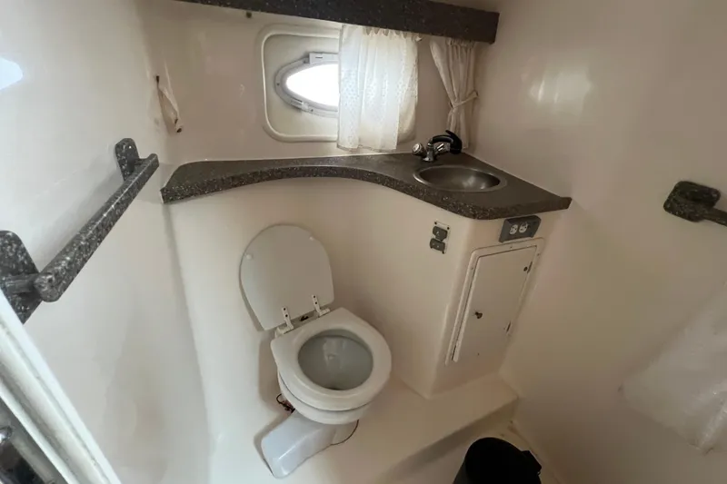Slide: The Image of 2005 Rinker Fiesta Vee 320 boat bathroom with toilet, sink, and small window. - 8