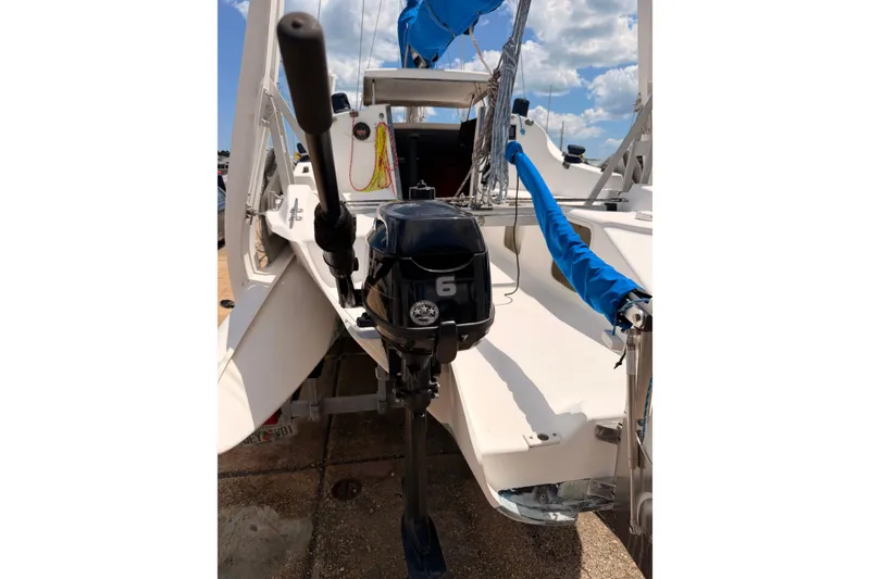 Slide: The Image of 2000 Corsair F-24 MkII sailboat with outboard motor, docked under a sunny sky. - 10