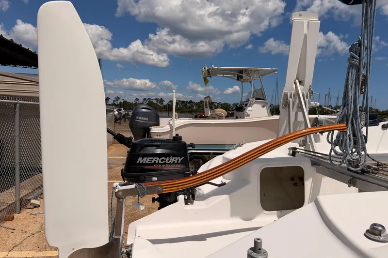 Slide: The Image of Corsair F-24 MkII sailboat with Mercury outboard motor, docked under a clear blue sky. - 12