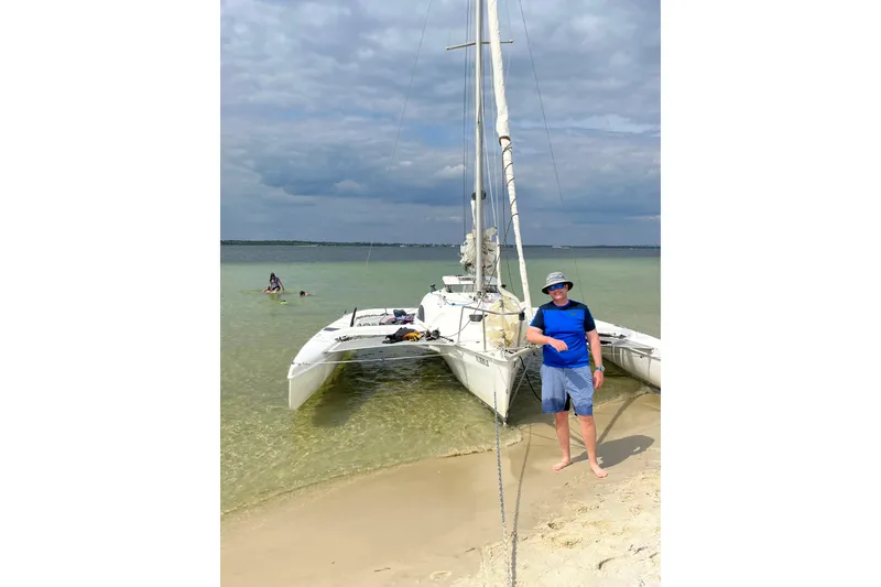 Slide: The Image of Man standing by Corsair F-24 MkII trimaran on sandy beach, 2000 model. - 6
