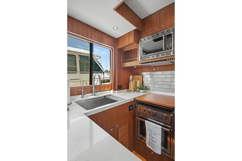Slide: The Image of Modern kitchen in 2022 North Pacific 45 Pilothouse yacht with sleek appliances and wood finish. - 16