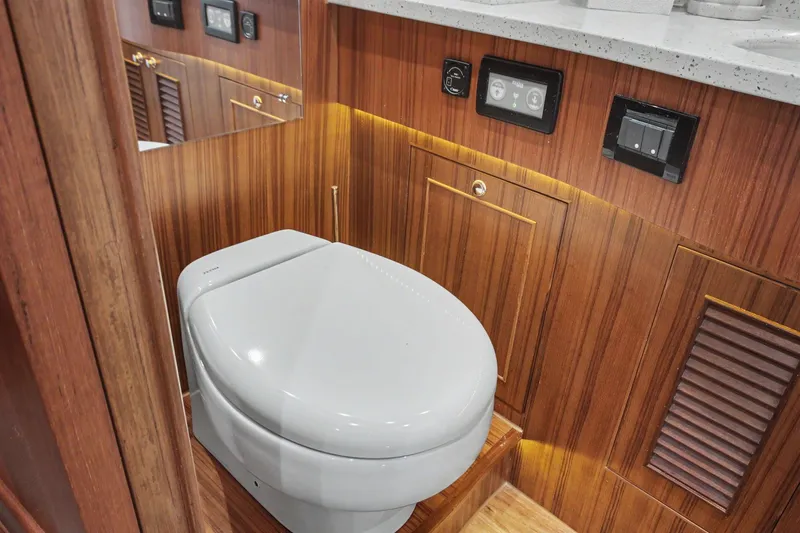 Slide: The Image of Luxury bathroom in 2022 North Pacific 45 Pilothouse yacht with modern toilet and wood paneling. - 27