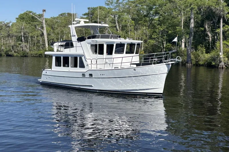 Slide: The Image of 2022 North Pacific 45 Pilothouse yacht cruising on a serene river. - 3