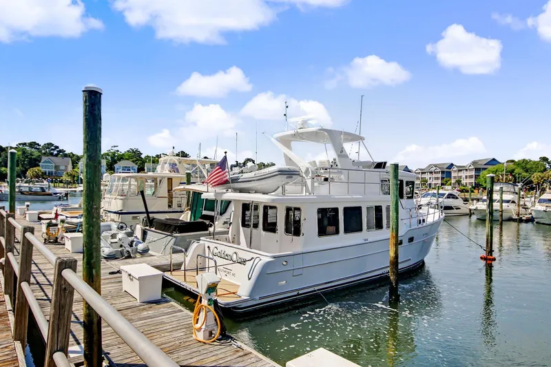 Slide: The Image of North Pacific 45 Pilothouse yacht docked at marina, 2022 model, under clear blue sky. - 6