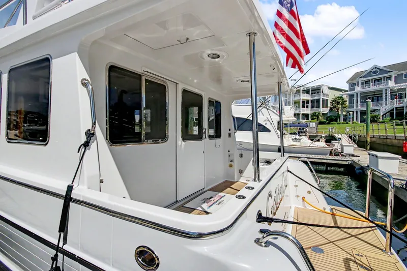 Slide: The Image of 2022 North Pacific 45 Pilothouse yacht docked at marina with American flag. - 8