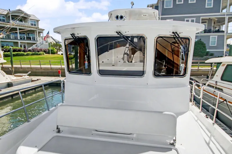 Slide: The Image of 2022 North Pacific 45 Pilothouse yacht docked near waterfront homes. - 36