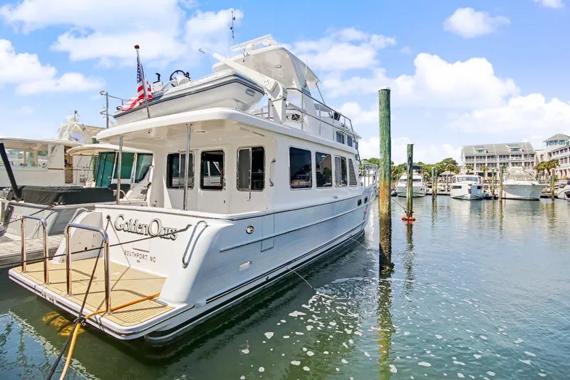 Slide: The Image of 2022 North Pacific 45 Pilothouse yacht docked in a marina under a clear blue sky. - 5